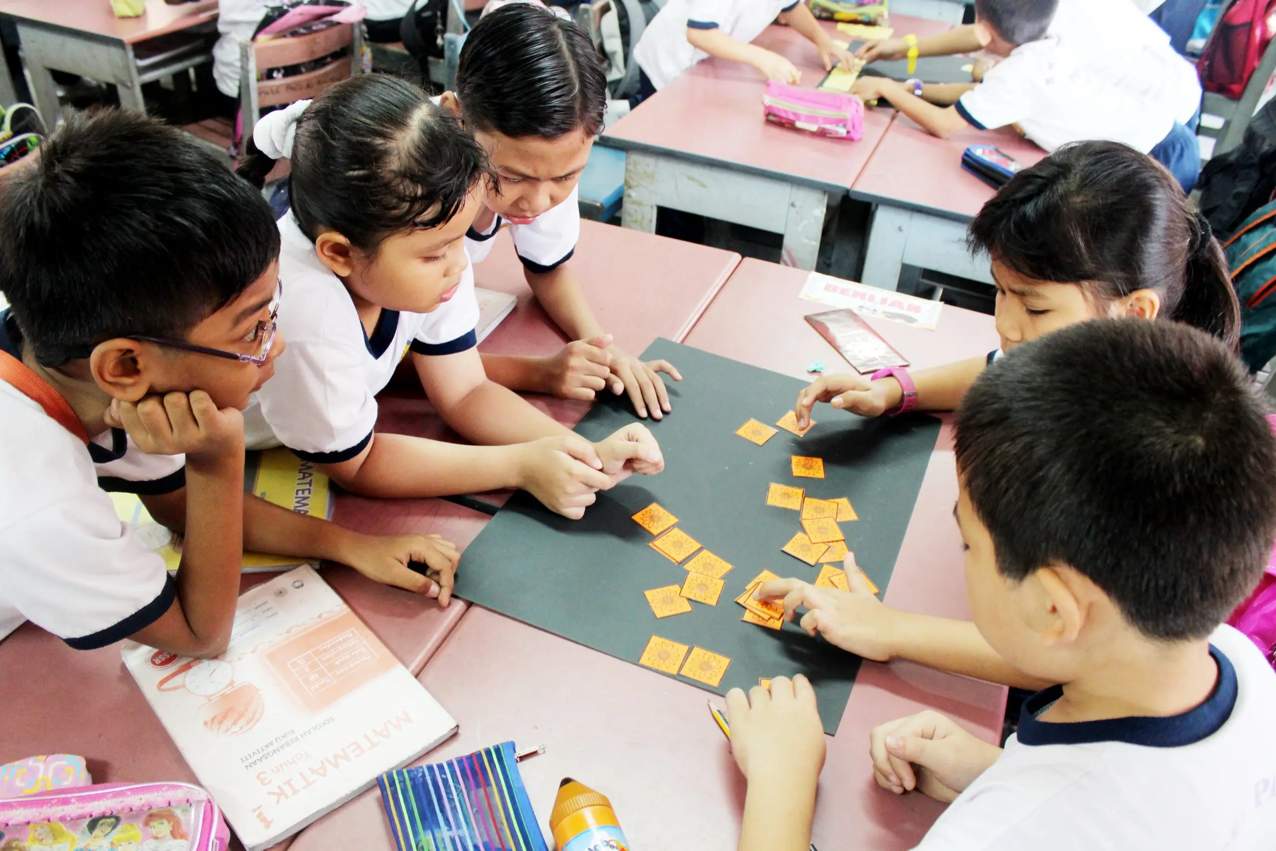 Primary school pupils working together with letter cards at a table