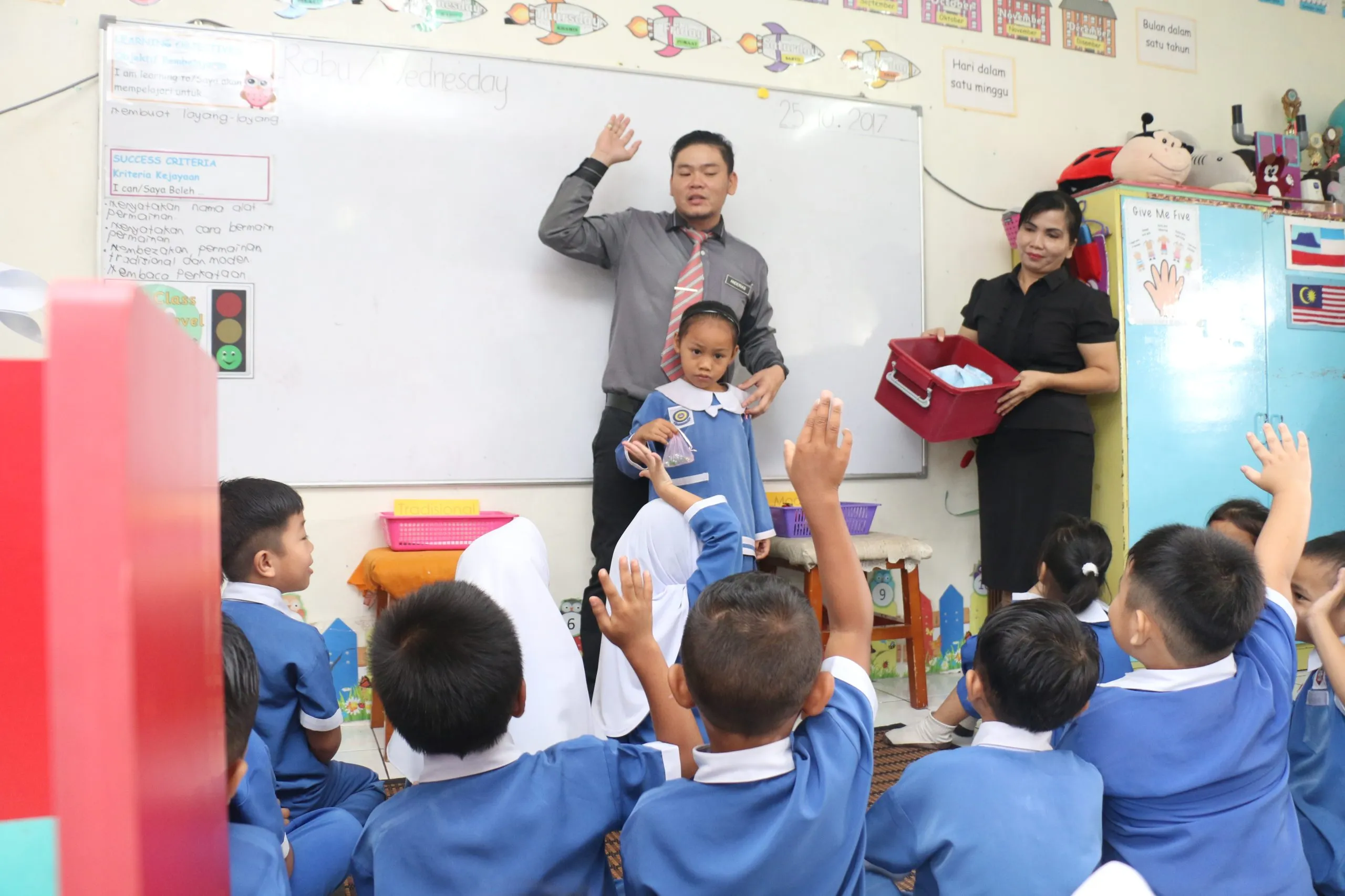 A teacher leading a lesson with young pupils seated on the floor