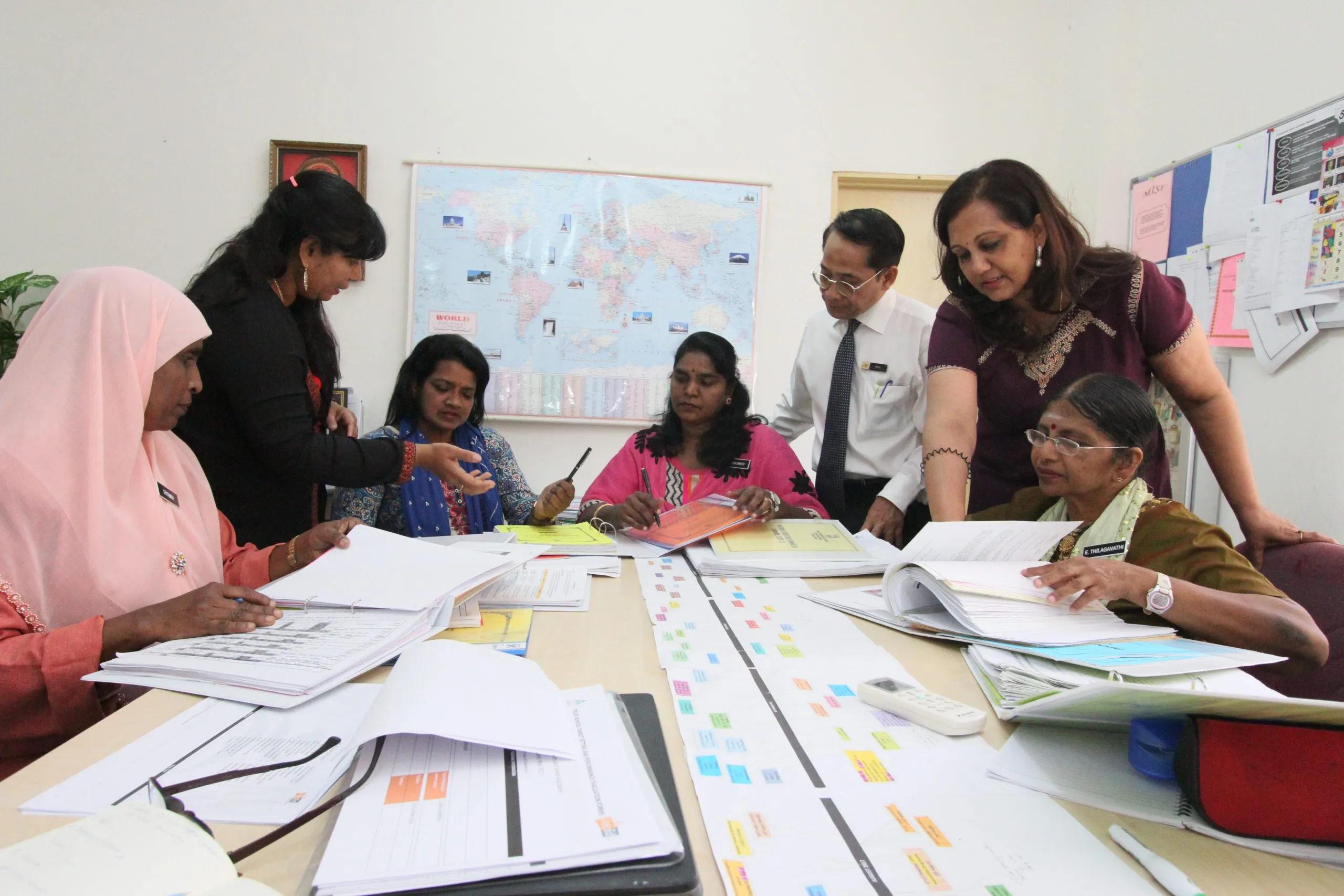 Teachers working together on lesson materials at a table