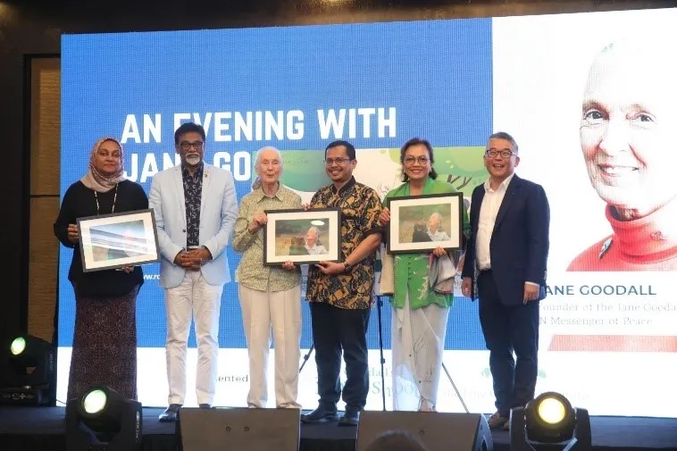 Guests on stage holding framed pictures at an evening event